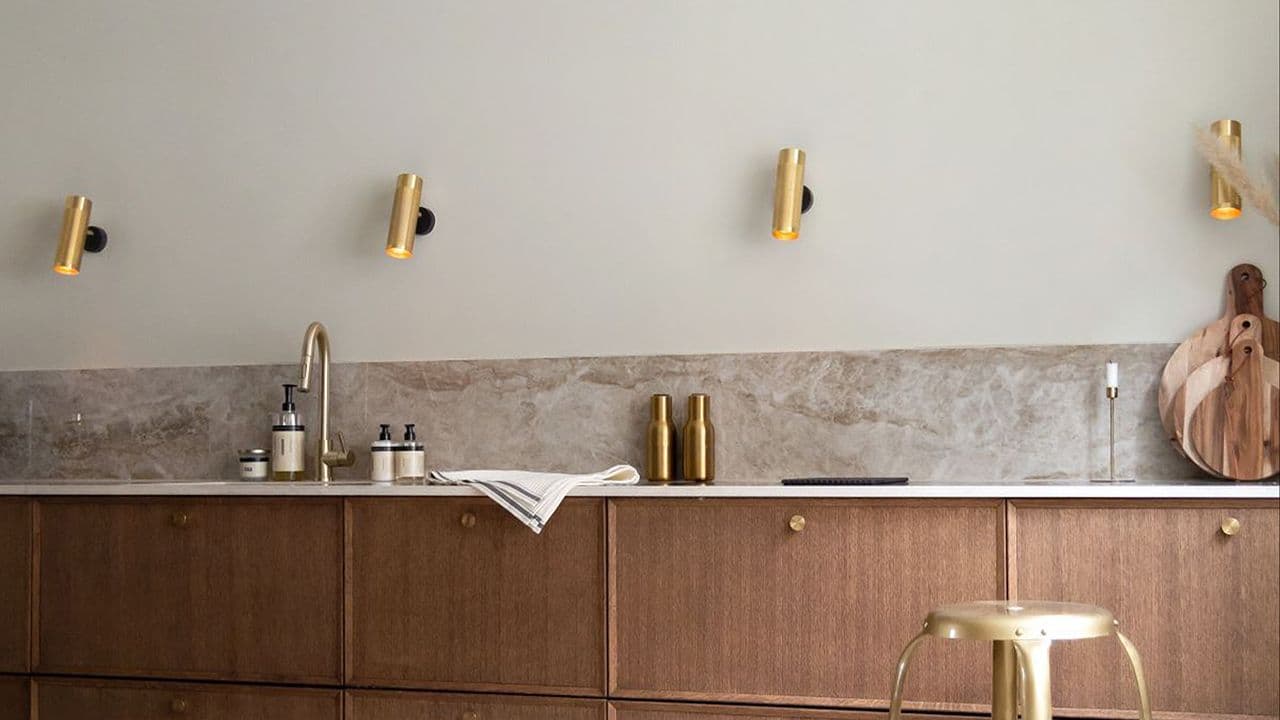 Flott kjøkken med brune fronter og vegg malt i lun beige farge.