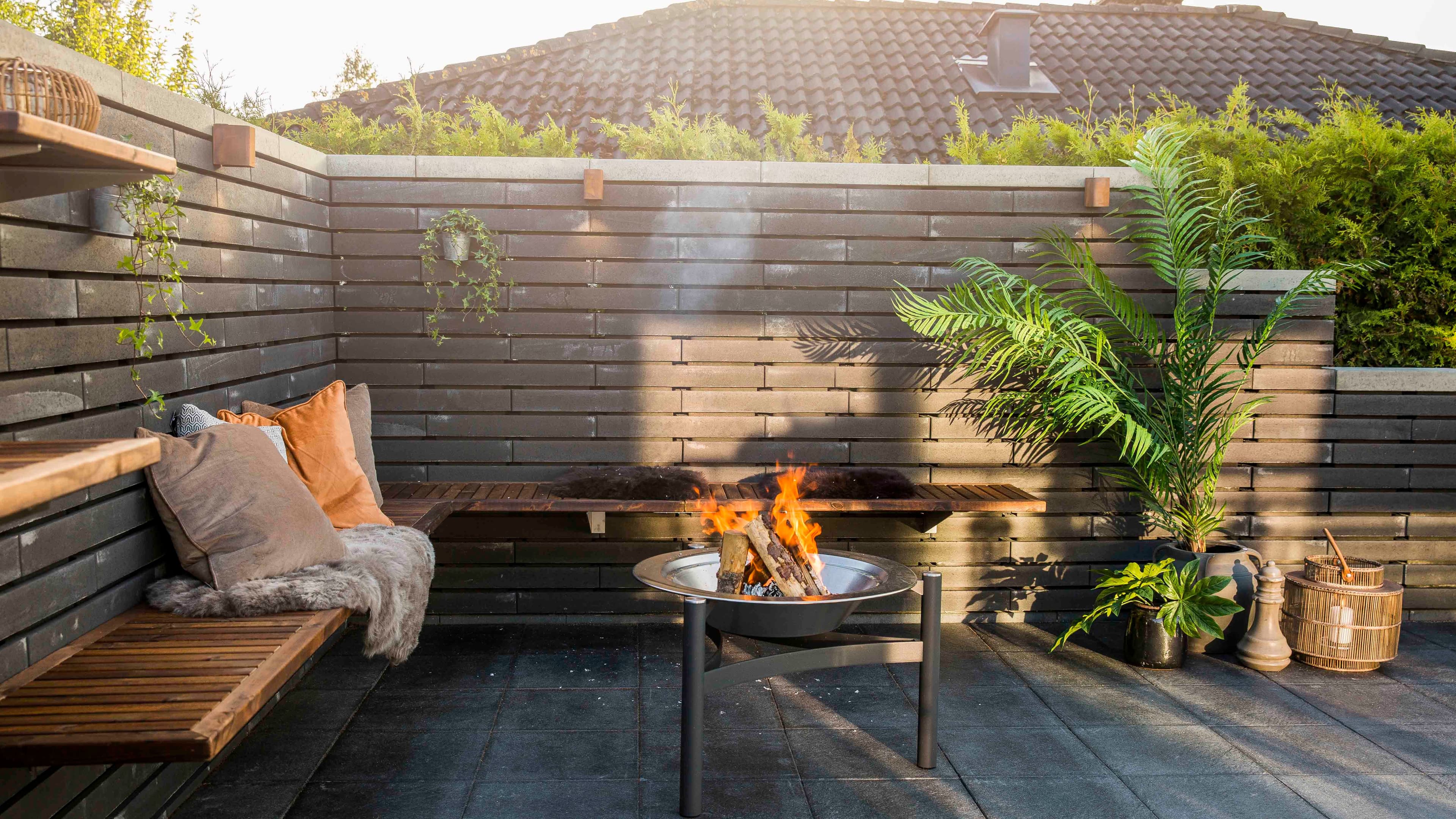 Sitteplass med benk og mur.