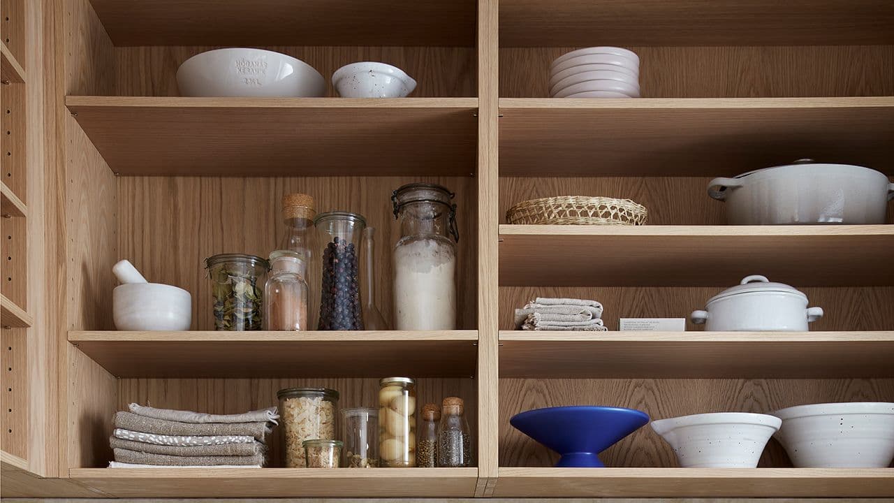 Kjøkken med åpne hyller i høyden for å utnytte takhøyden.