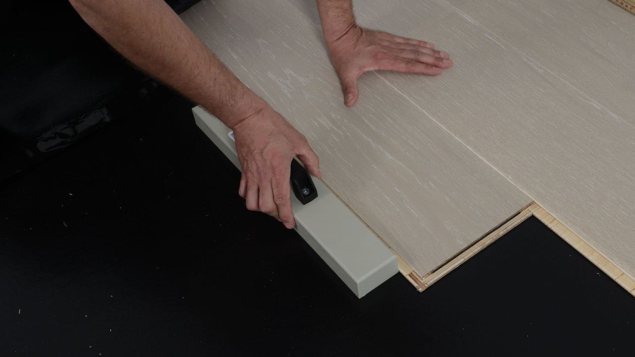 Person som legger nytt gulv.