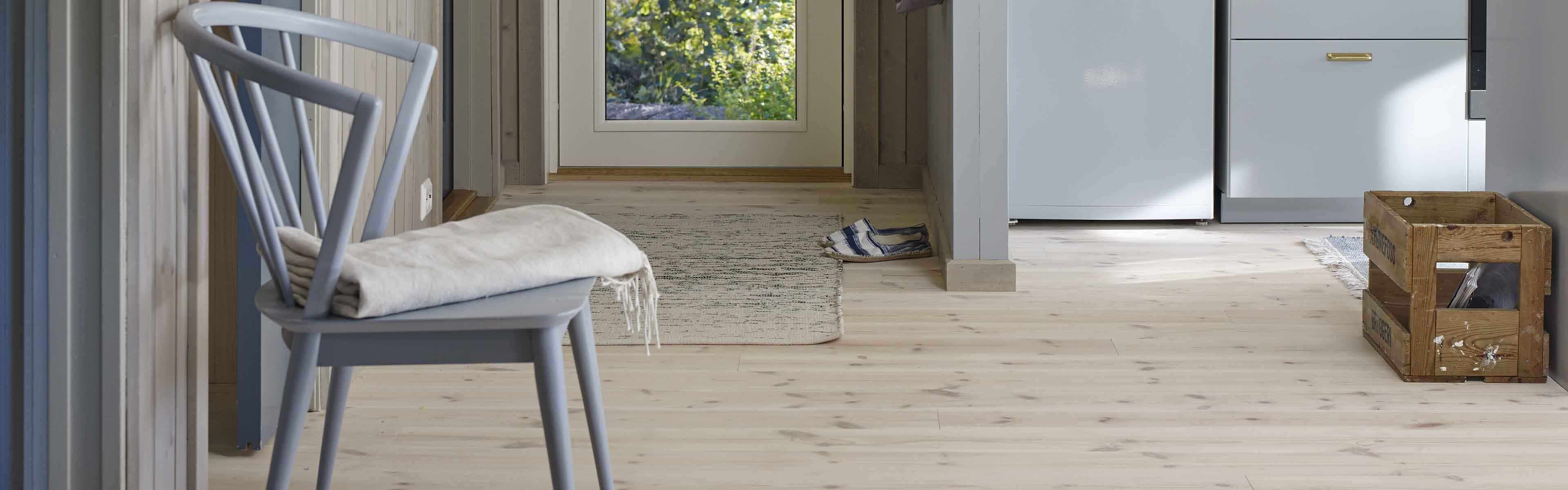 Furugulv i lyseblått kjøkken og gang.