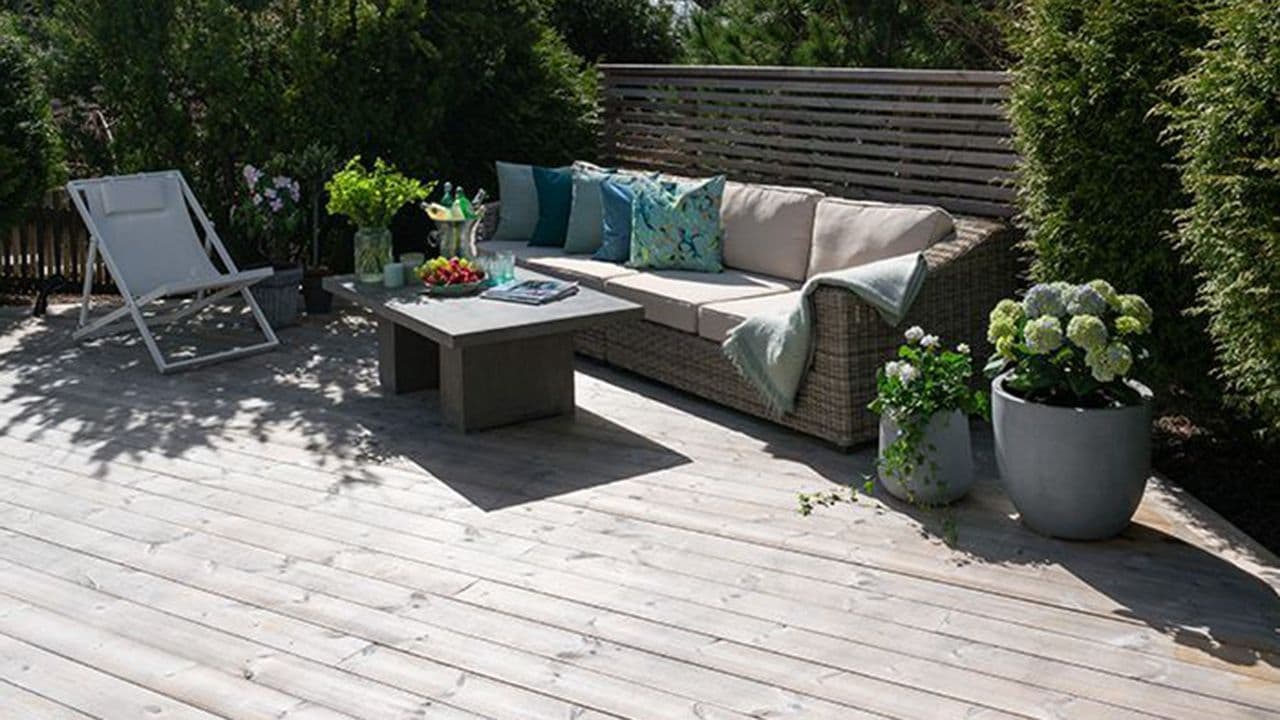 Varmebehandlet terrassegulv i termofuru på terrasse med levegg med spiler.