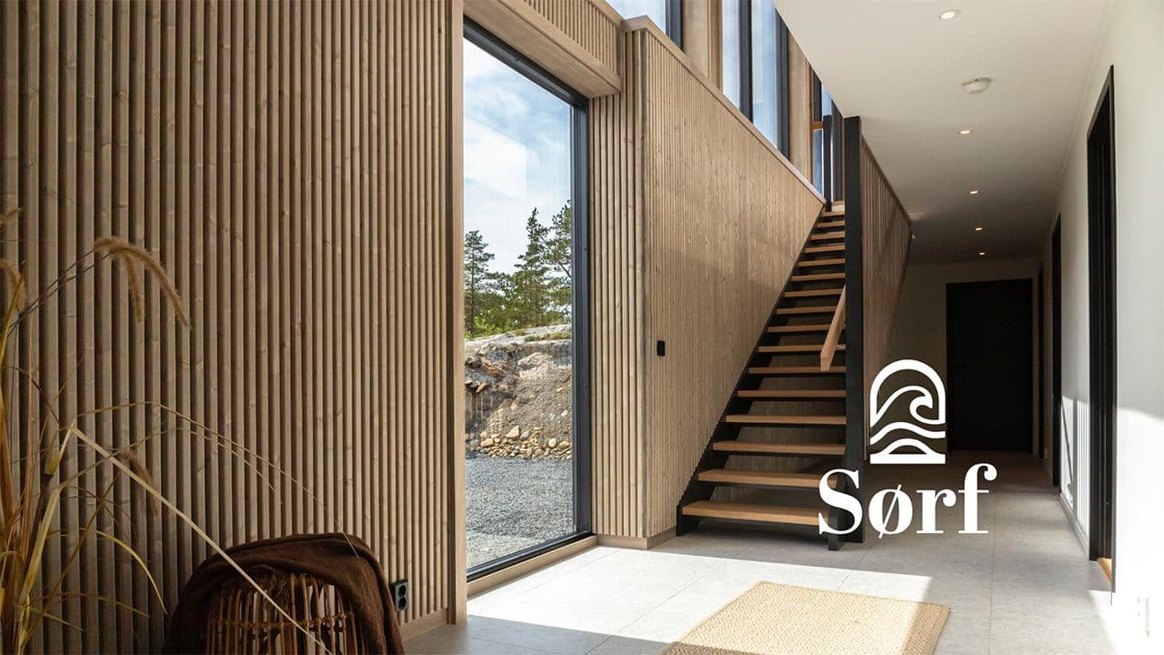 Hus med Sørf Tide avrundede spiler i Drivvedgrå på veggene.