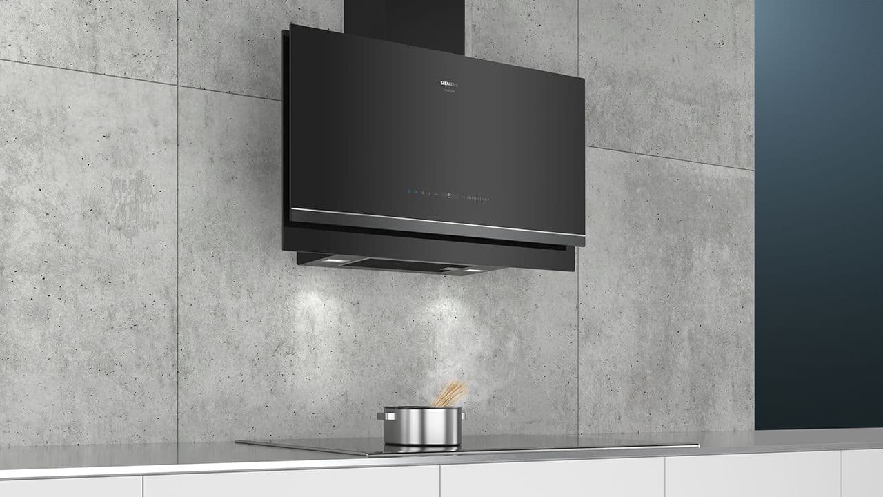 Veggmontert kjøkkenventilator på grå vegg.