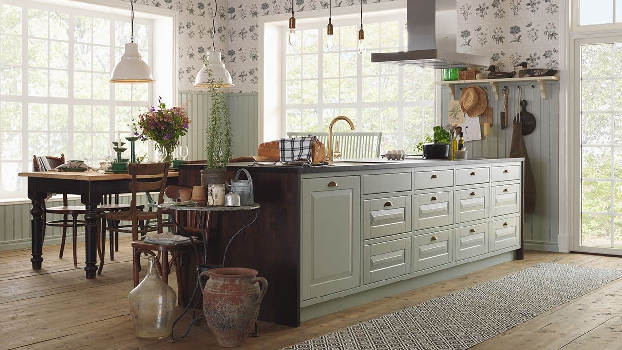 Landlig kjøkken i dus grønn og mørkebrunt.