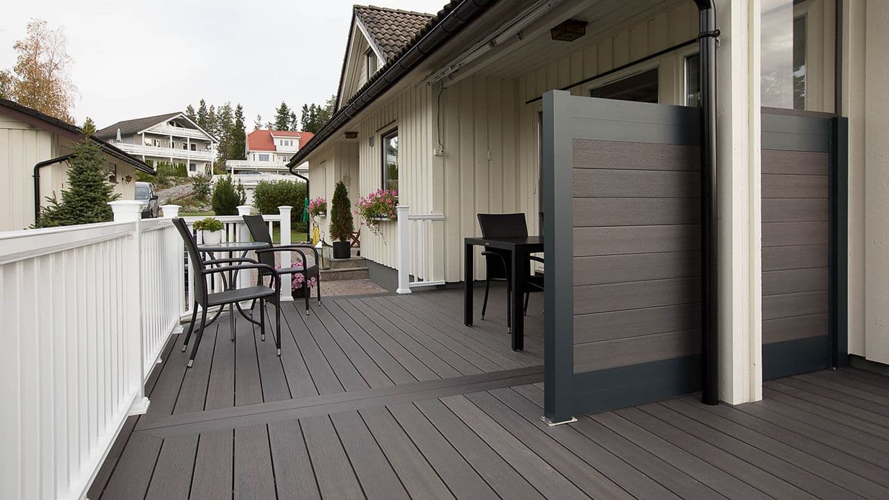 Terrasse med terrassebord i kompositt og matchende levegg.