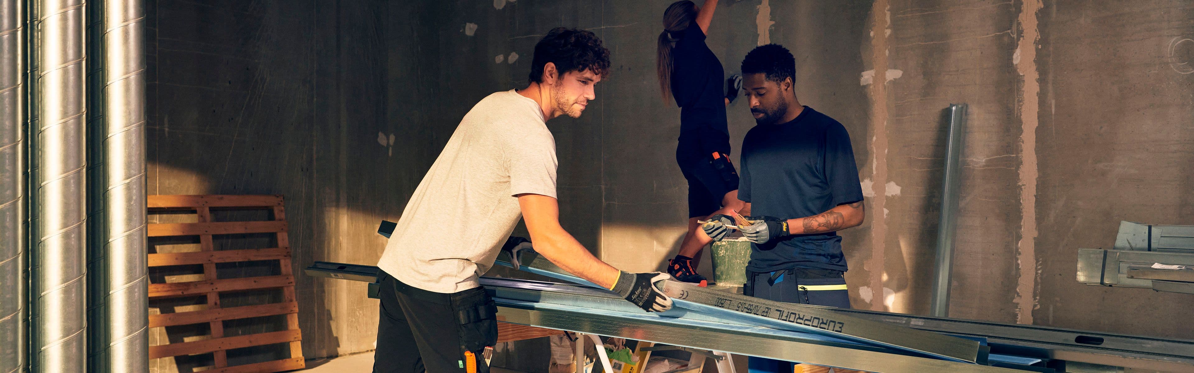 kvinnelig håndverker i arbeidsskjørt sitter smilende i åpningen på en arbeidsbil