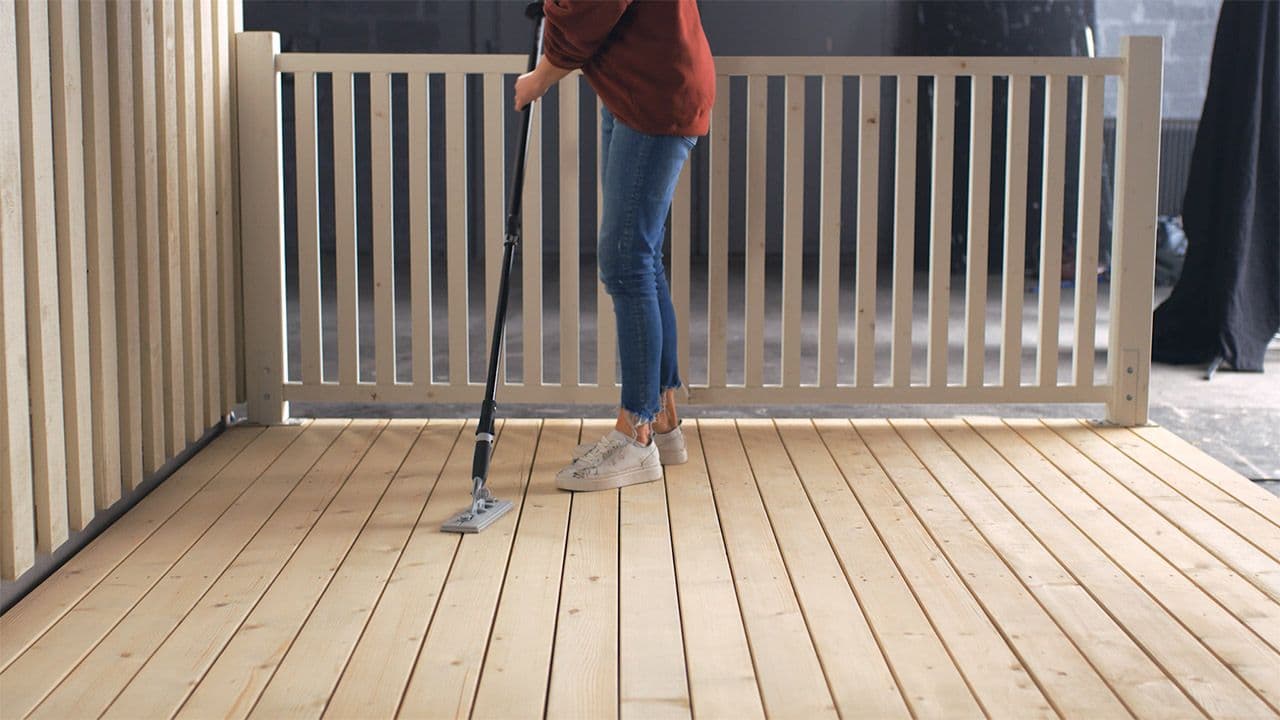 Kvinne som holder på å slipe terrasse.
