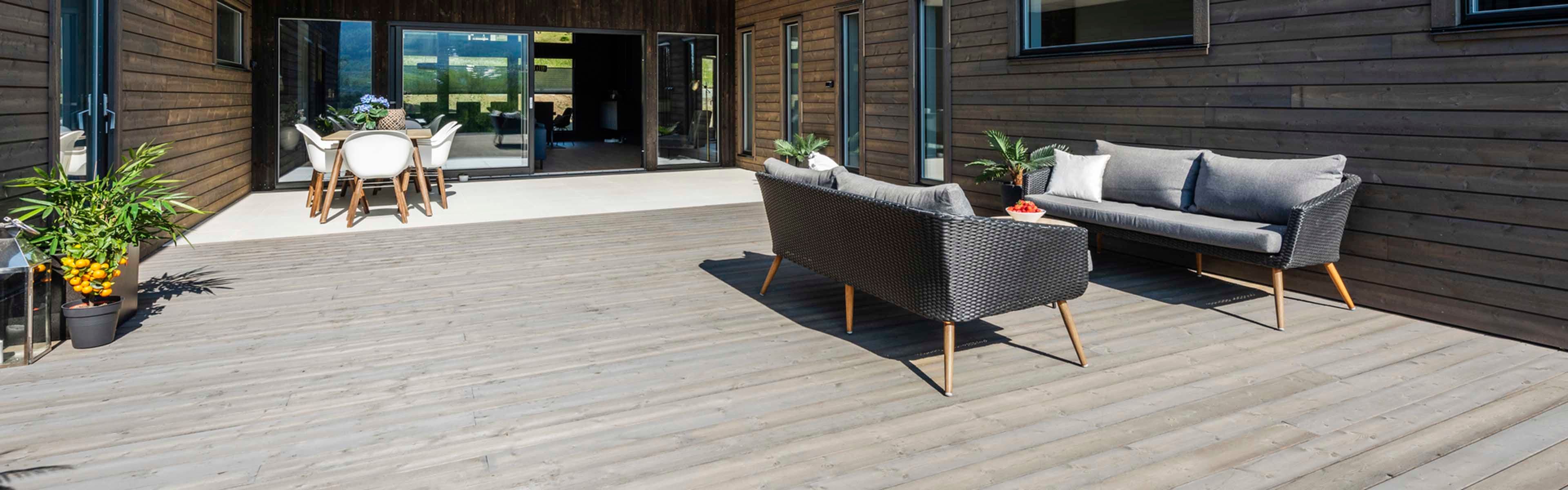 Stor terrasse med Concise terrassebord og to sittegrupper.