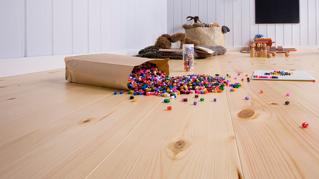 Heltregulv med en pose fargerike perler som velter utover