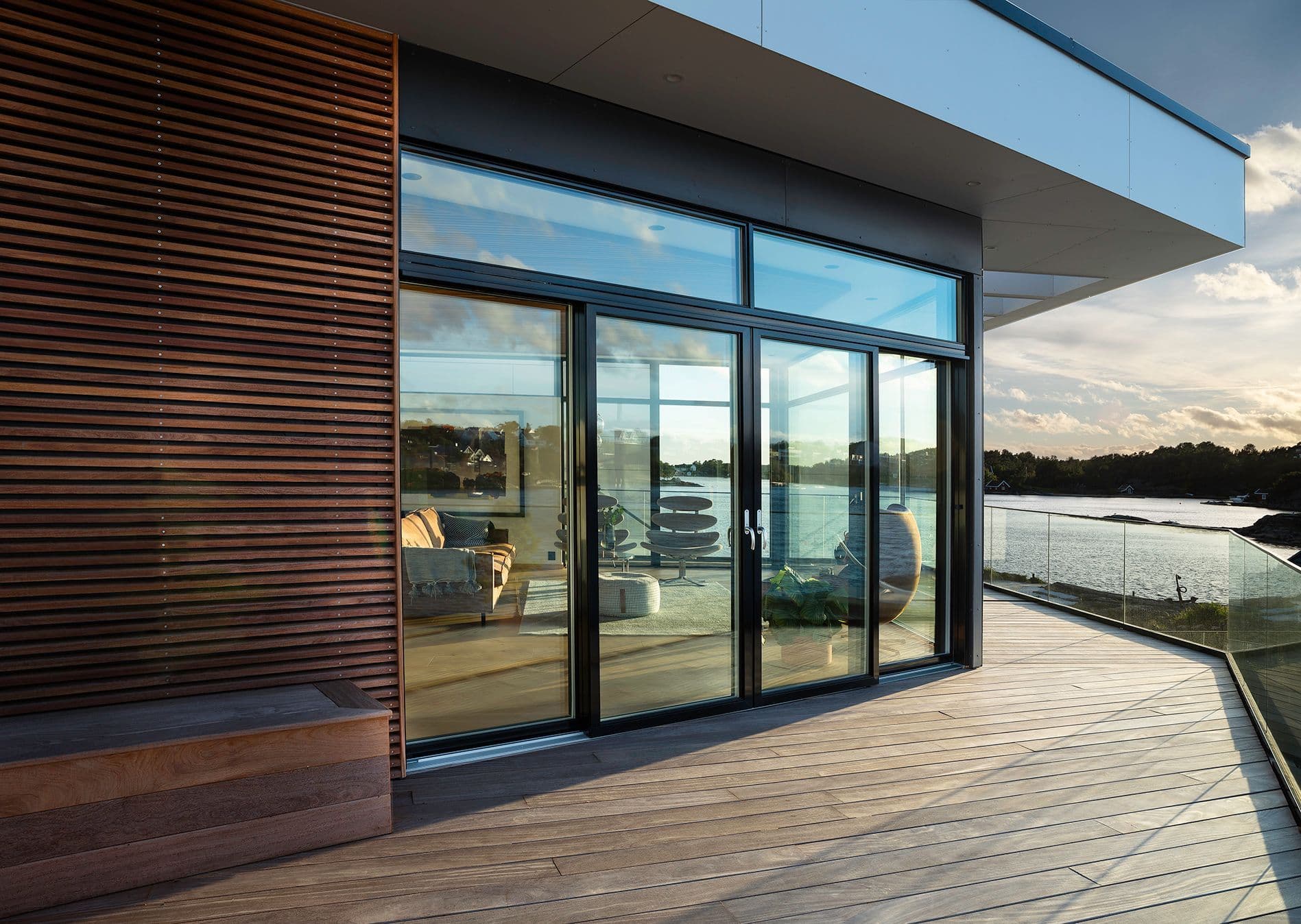 moderne hus med sorte skyvedører i glass mot terrassen