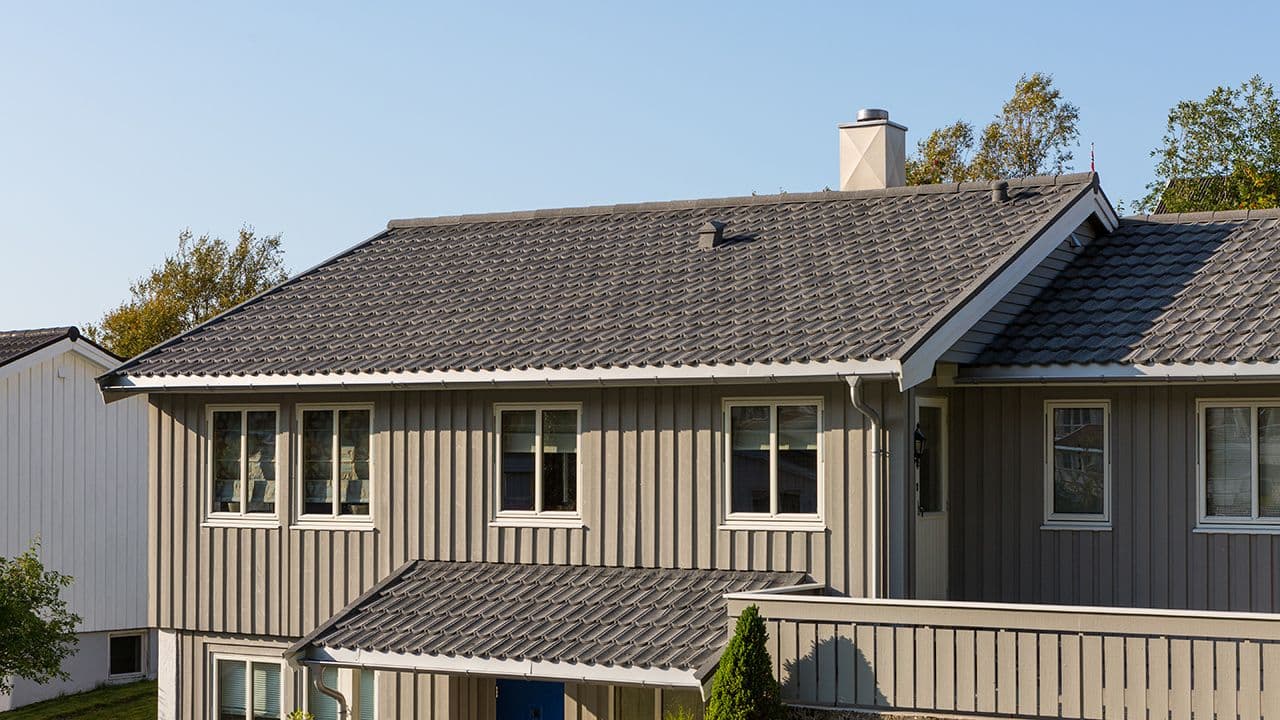 Takpanner stål på grått hus.
