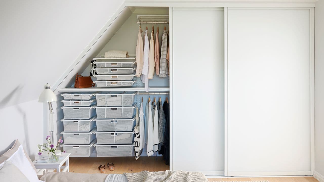 Skyvedørsgarderobe i rom med skråtak.