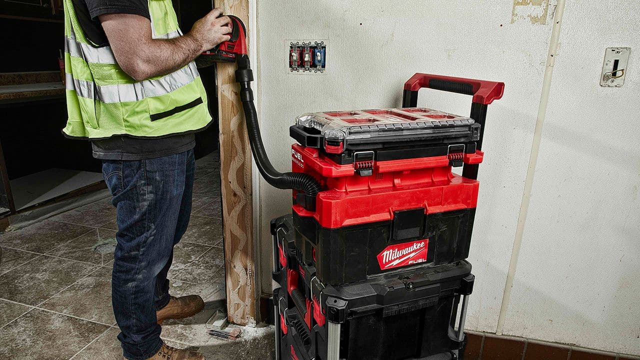 Håndverker som bruker støvavsug på verktøy.