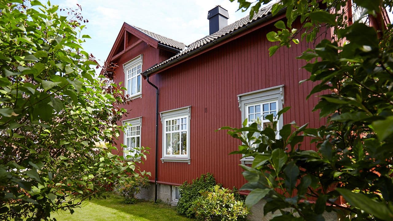 Moderne kledning på gammelt hus i rødt.