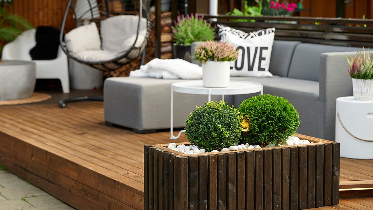 Royalimpregnerte terrassegulv på terrasse med sittegruppe og blomsterkasse i samme materiale.