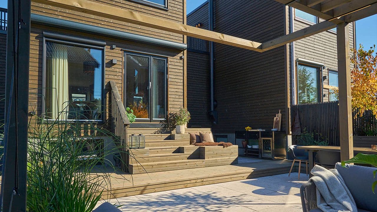 Stort uteområde med bred trapp og terrasse av lekter.