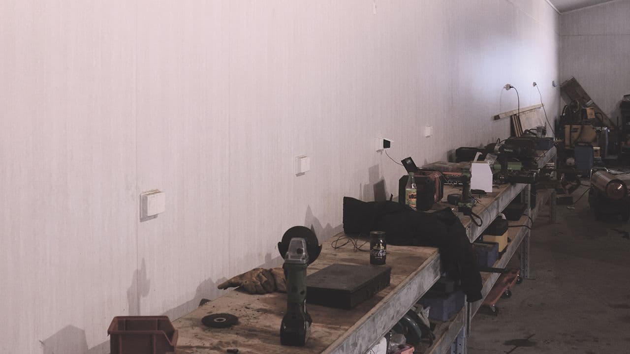 Forestia eliteX veggplater i driftsbygning med arbeidsbenker, verktøy og gårdsutstyr.