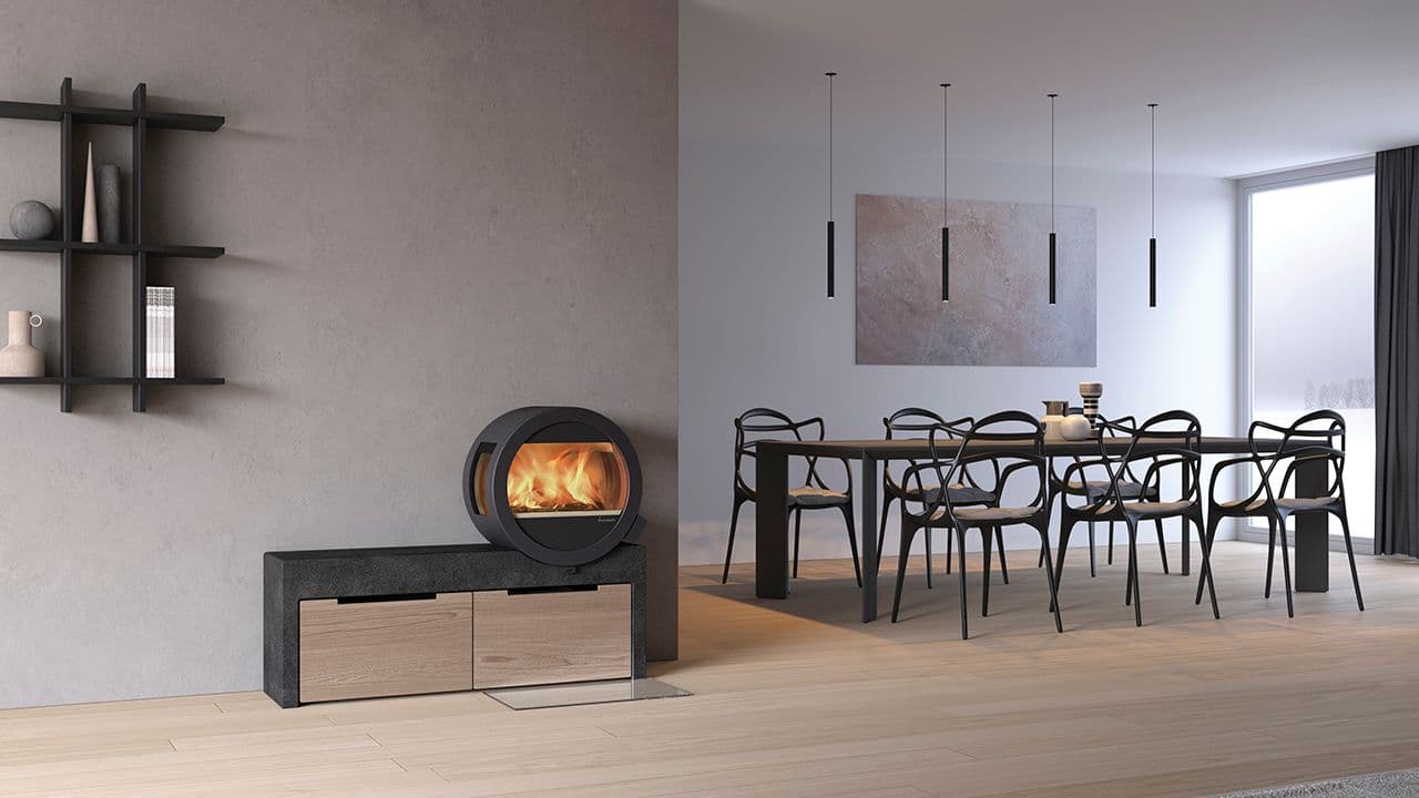 Lav rund peis fra Nordpeis med tilhørende benk for oppbevaring.