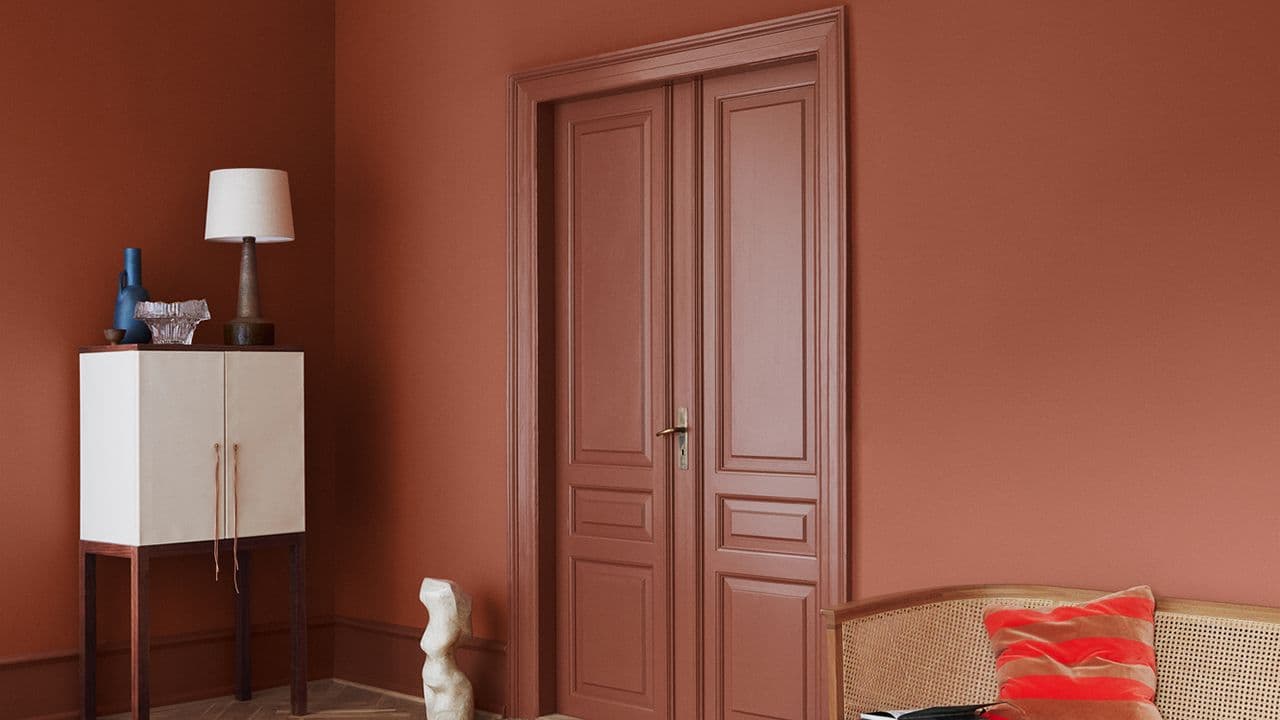 Vegg og dør i stue som er malt i forskjellige glansgrader.