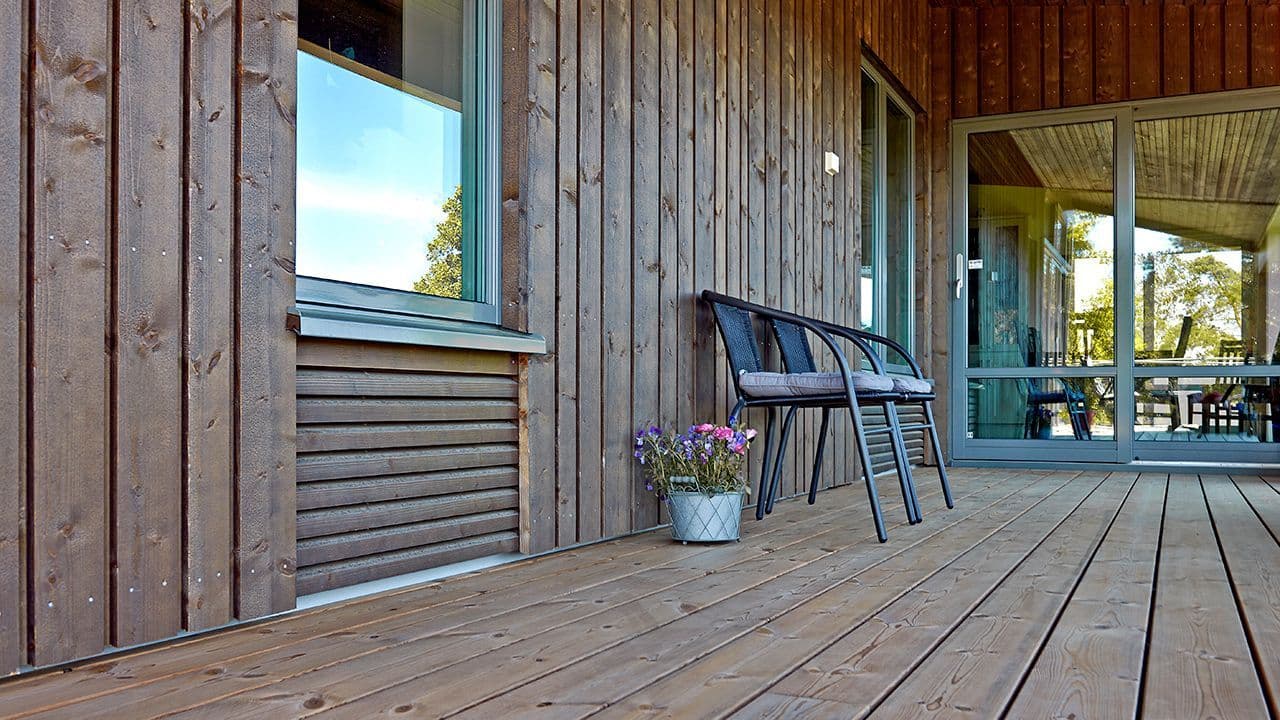 Brun terrasse i tilknytning til bygning bygget etter nye byggeregler 2021.