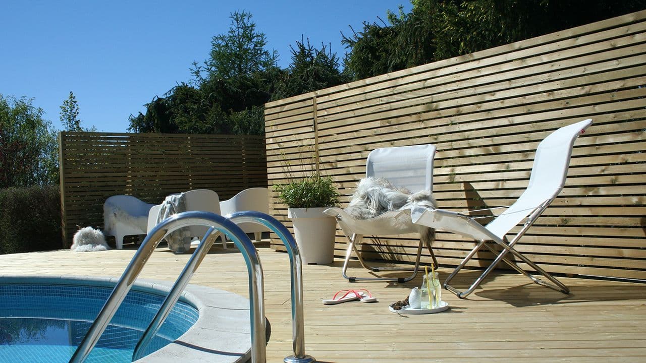 Spilevegg på terrasse i hage med basseng.