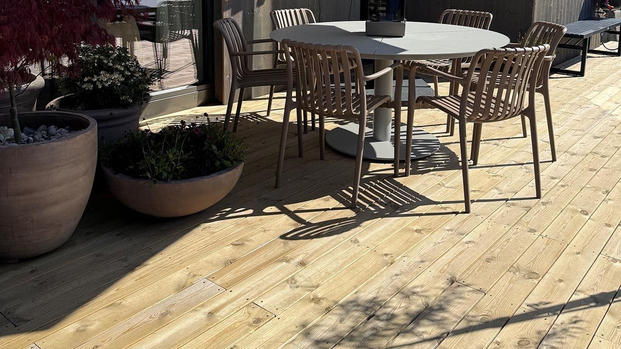Terrasse med sittegruppe og terrassebord i trykkimpregnert furu.