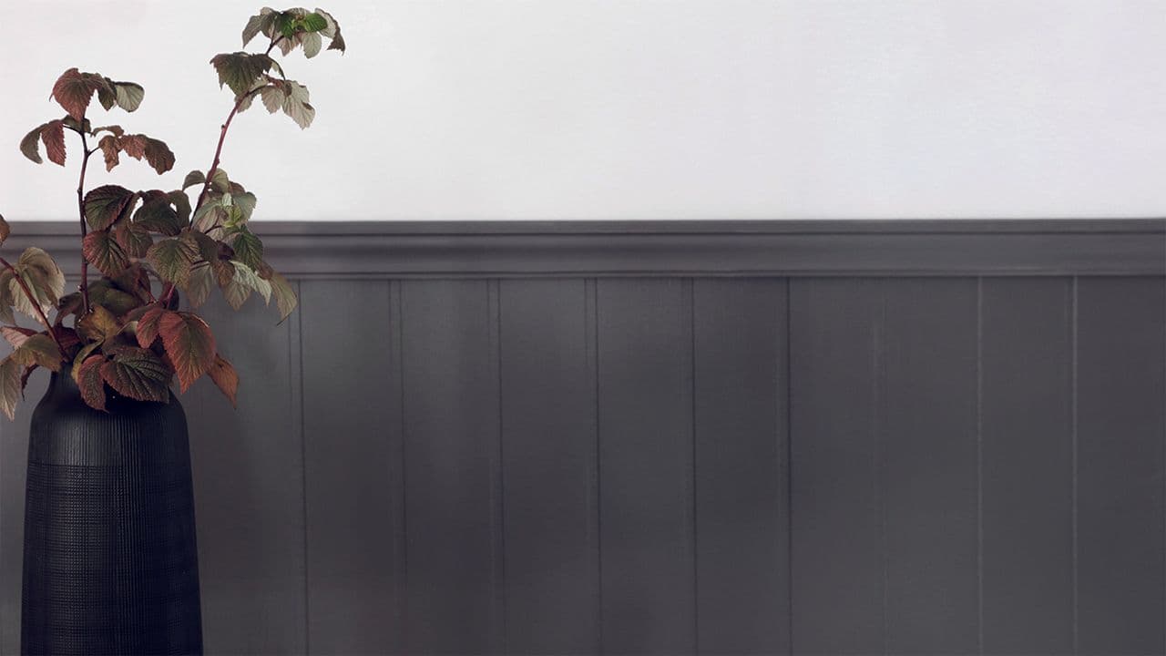 Svart brystpanel av lister og veggplate.