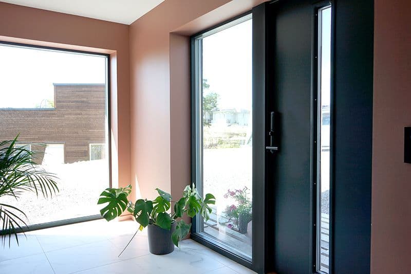 svart ytterdør med stort sidefelt i glass