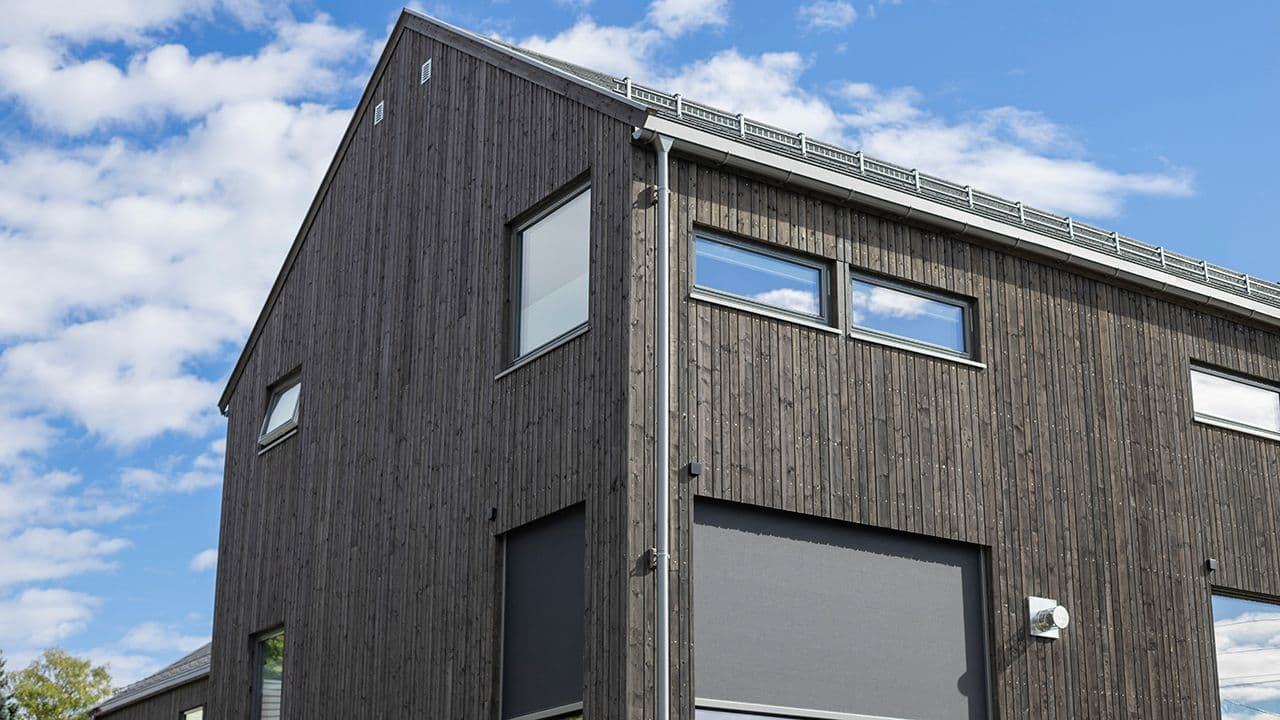 NORD stående kledning fra Bergene Holm på hus med mange vinduer.