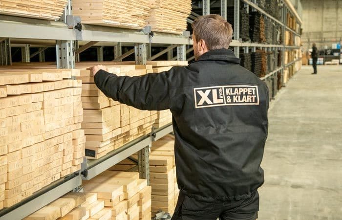 XL-BYGG-ansatt som plukker plank.