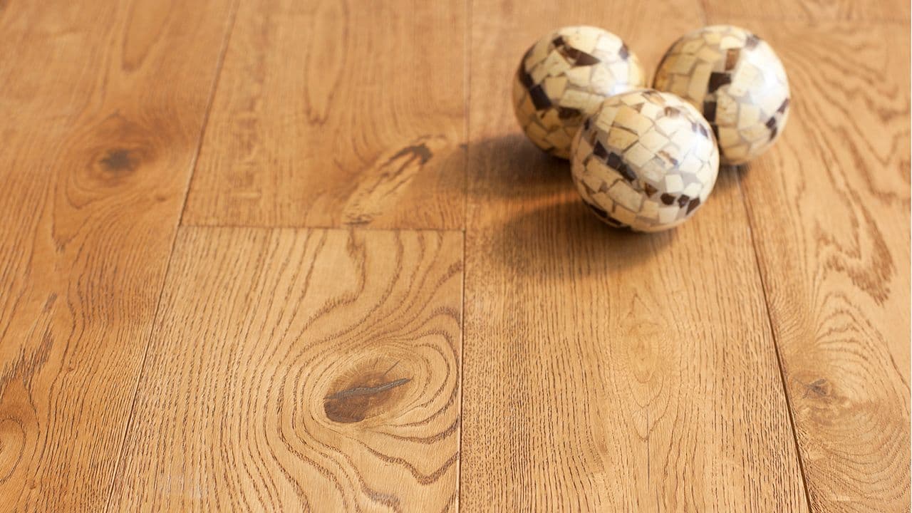 Nærbilde av heltre eikgulv med tre dekorballer på.