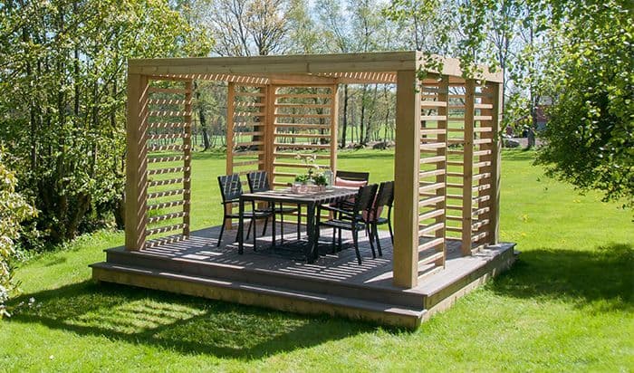 Frittstående pergola fra Bergene Holm med en spisegruppe i midten