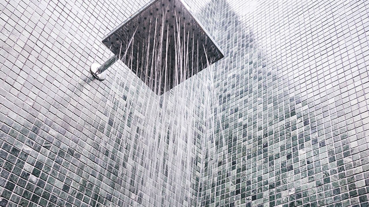 Dusjhode det kommer vann ut av på gulv med fall til sluk.