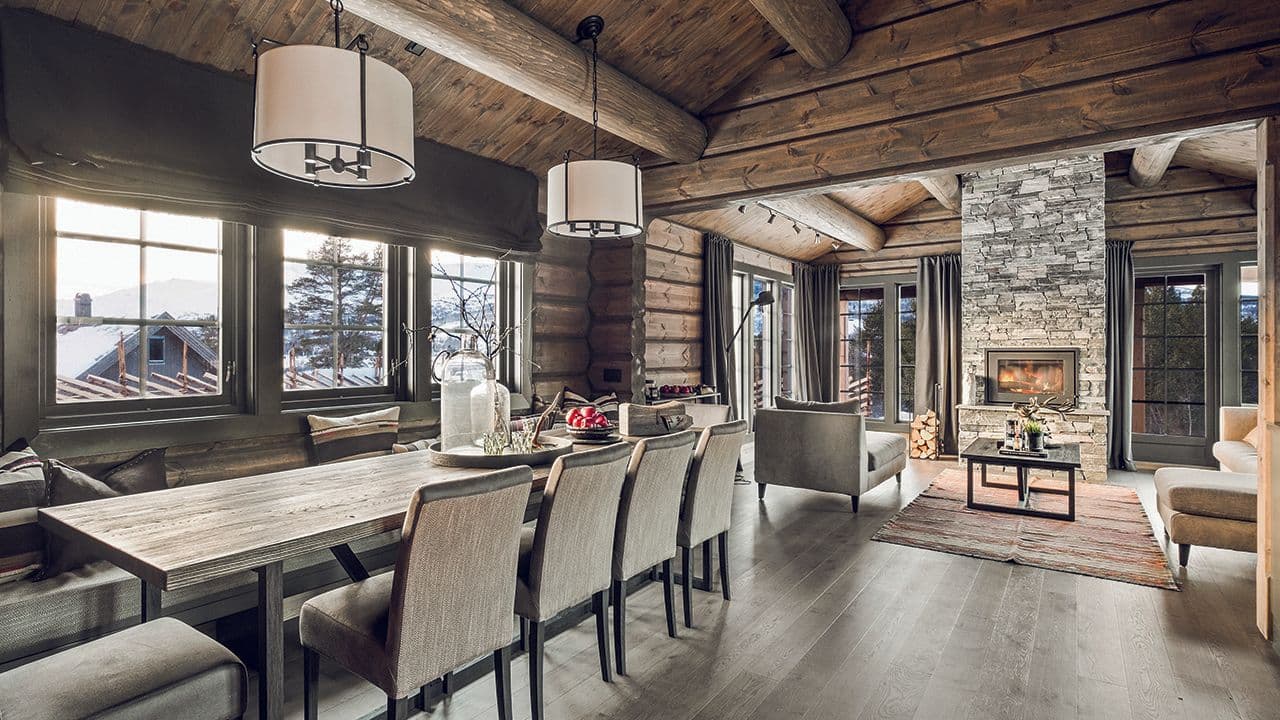 Hyttevinduer med sprosser i hytte med steinpeis og rustikk stil.