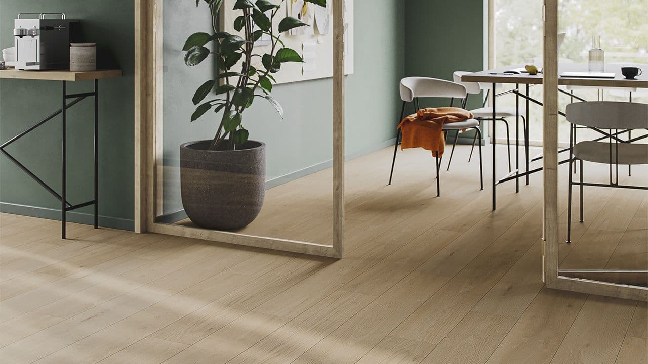 Lyst eik gulv mot grønnfarget vegg.