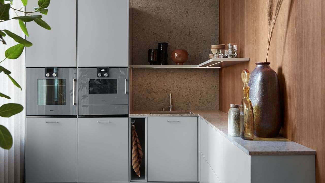 Kjøkken med åpen hylle ved siden av høyskap.