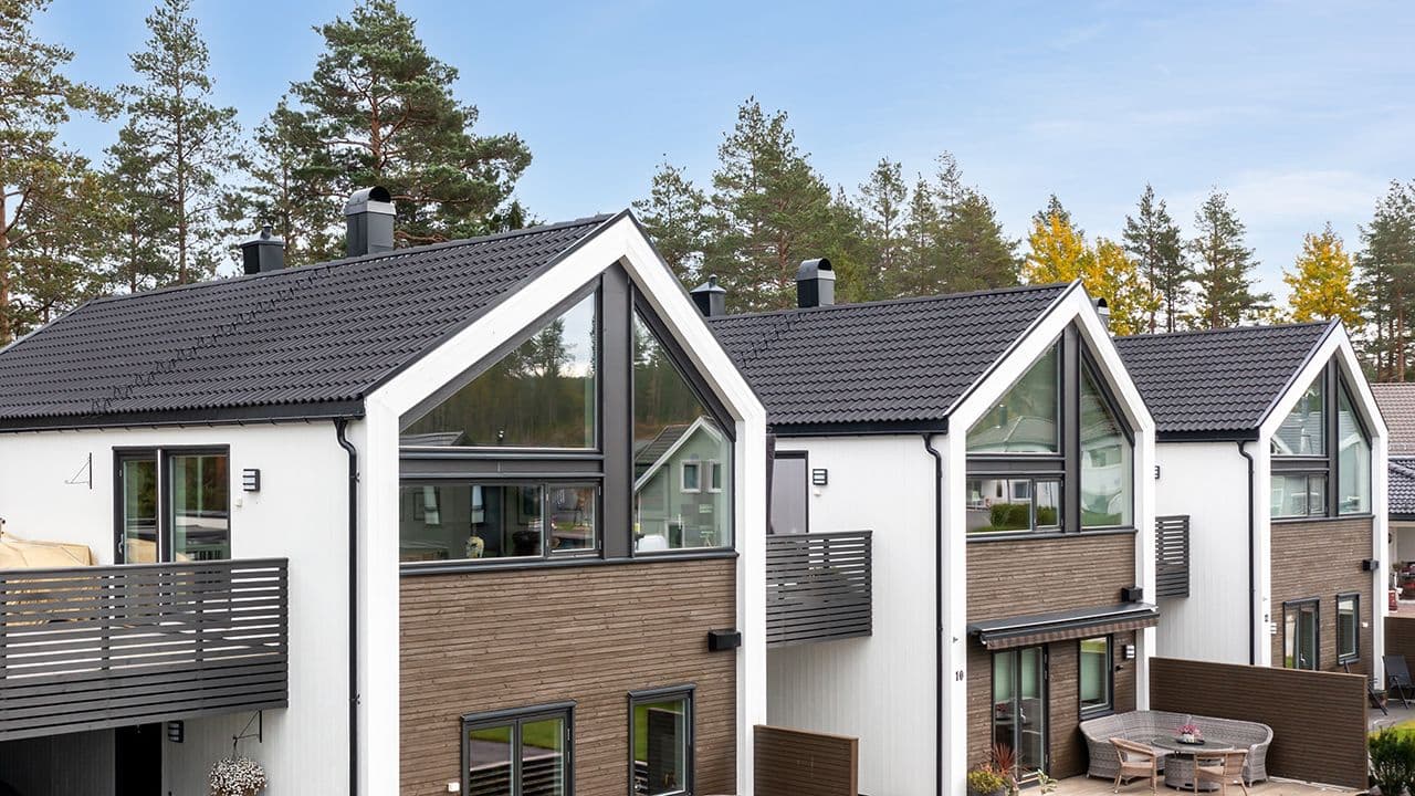 Tre boliger på rekke med svart takstein.